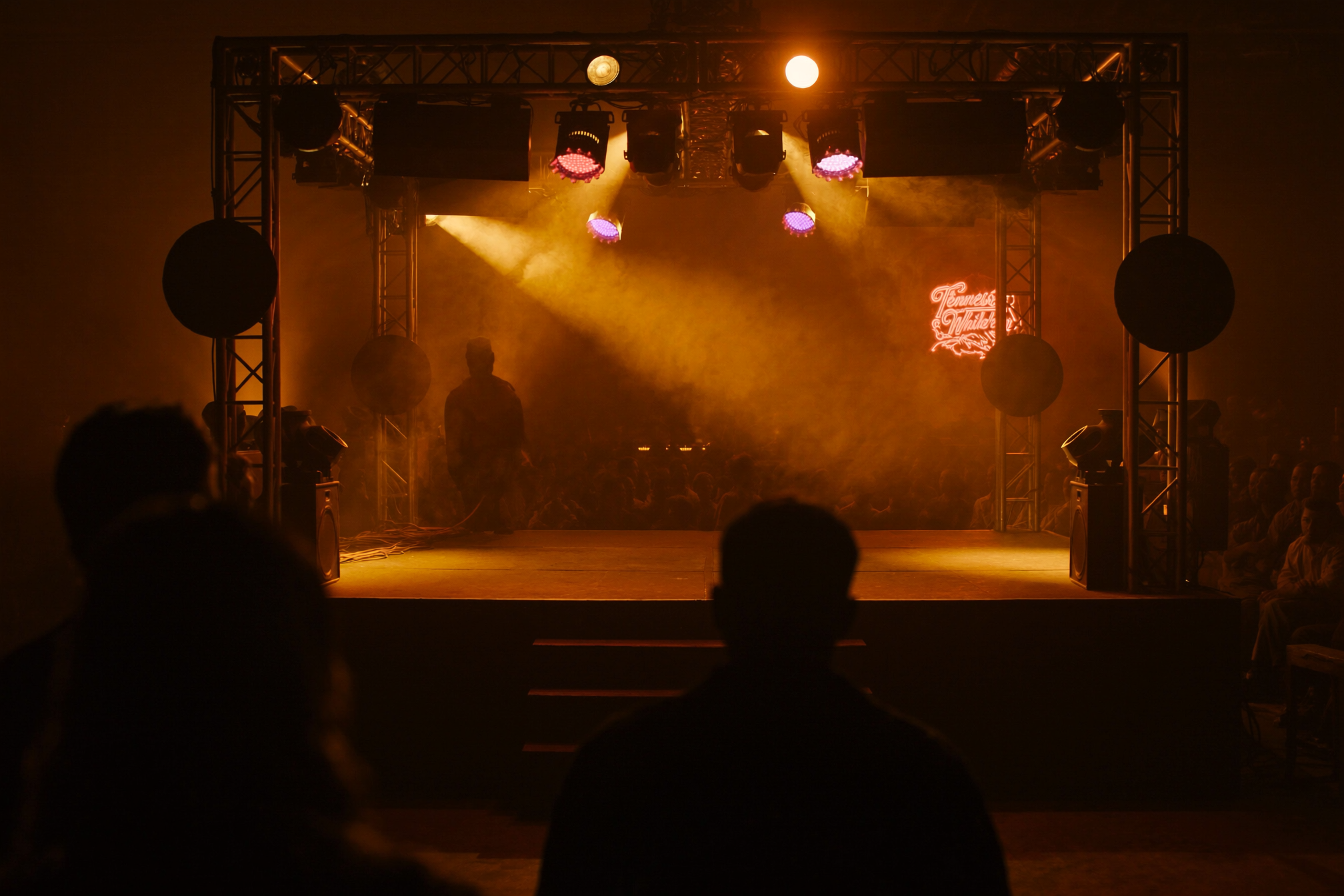 Interior of a Nashville honky-tonk with stage and warm tungsten lighting